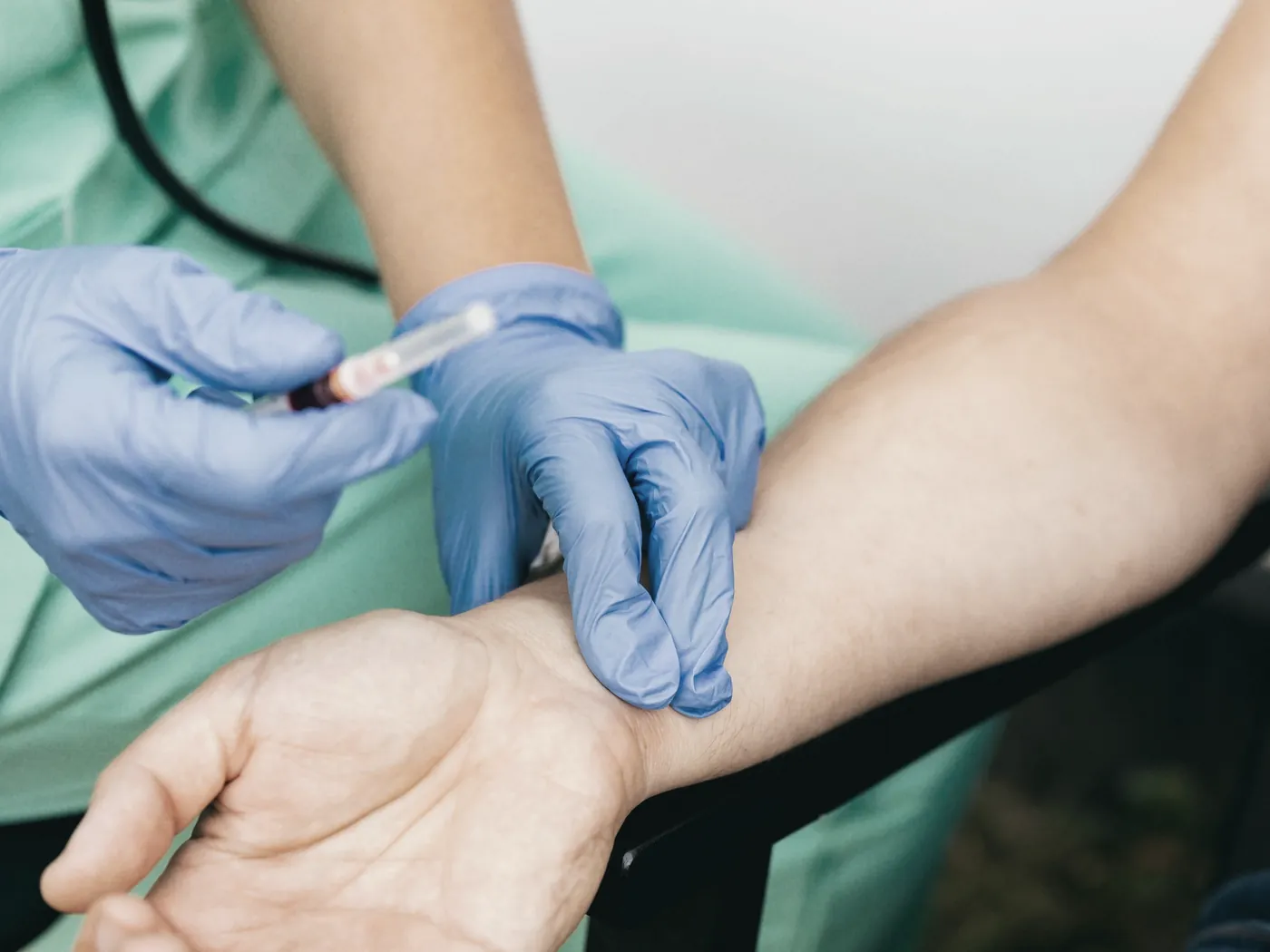 A clinician in gloves preparing a quick blood test