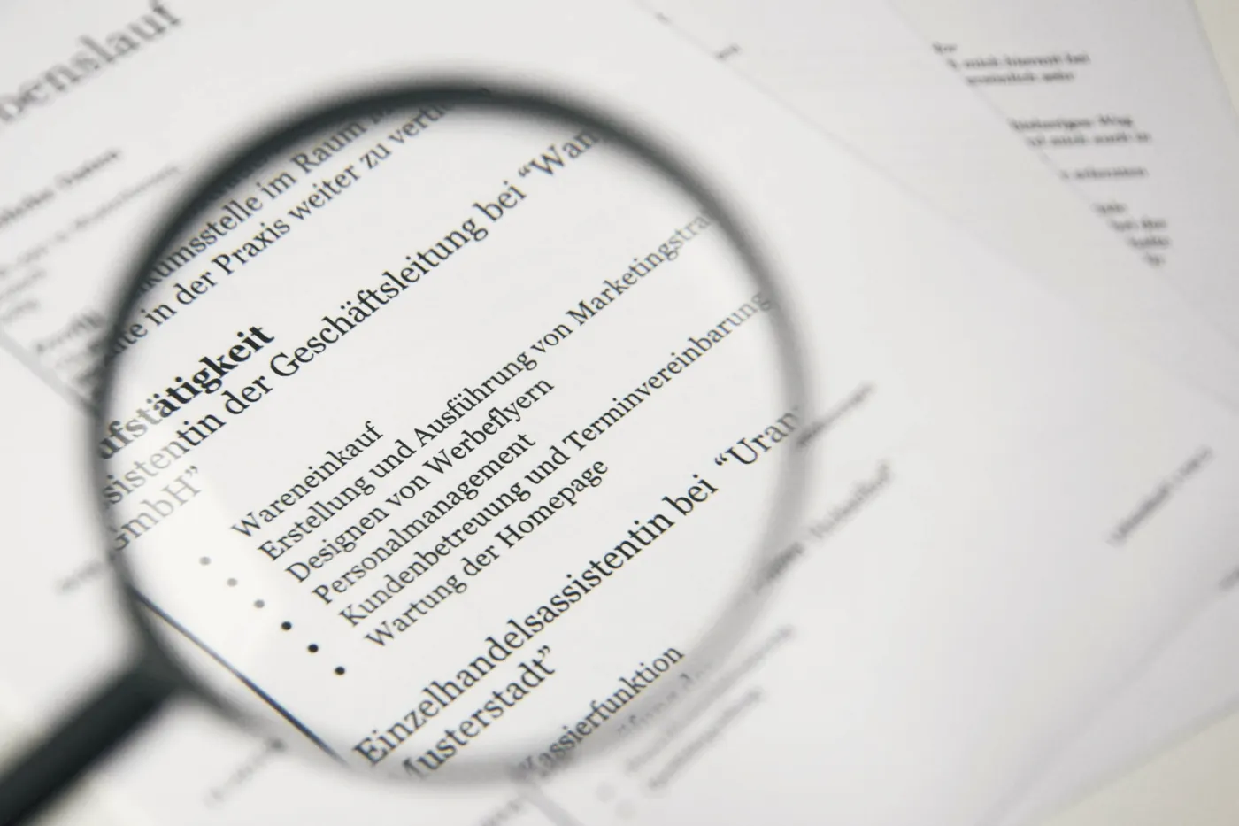 A magnifying glass resting on a printed document with small text