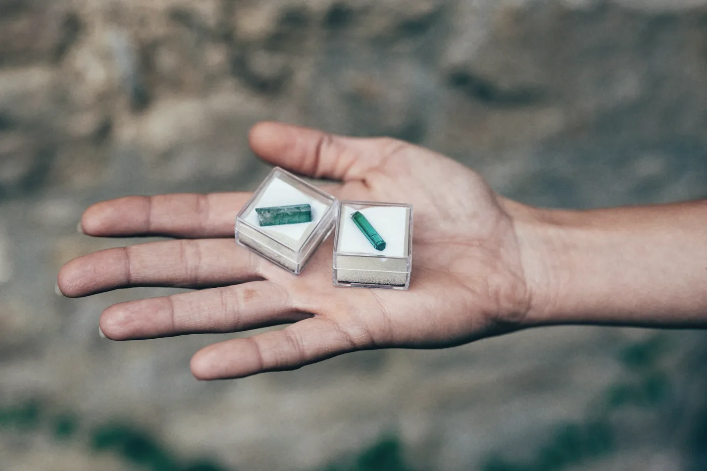 An open palm holding two small medicine boxes