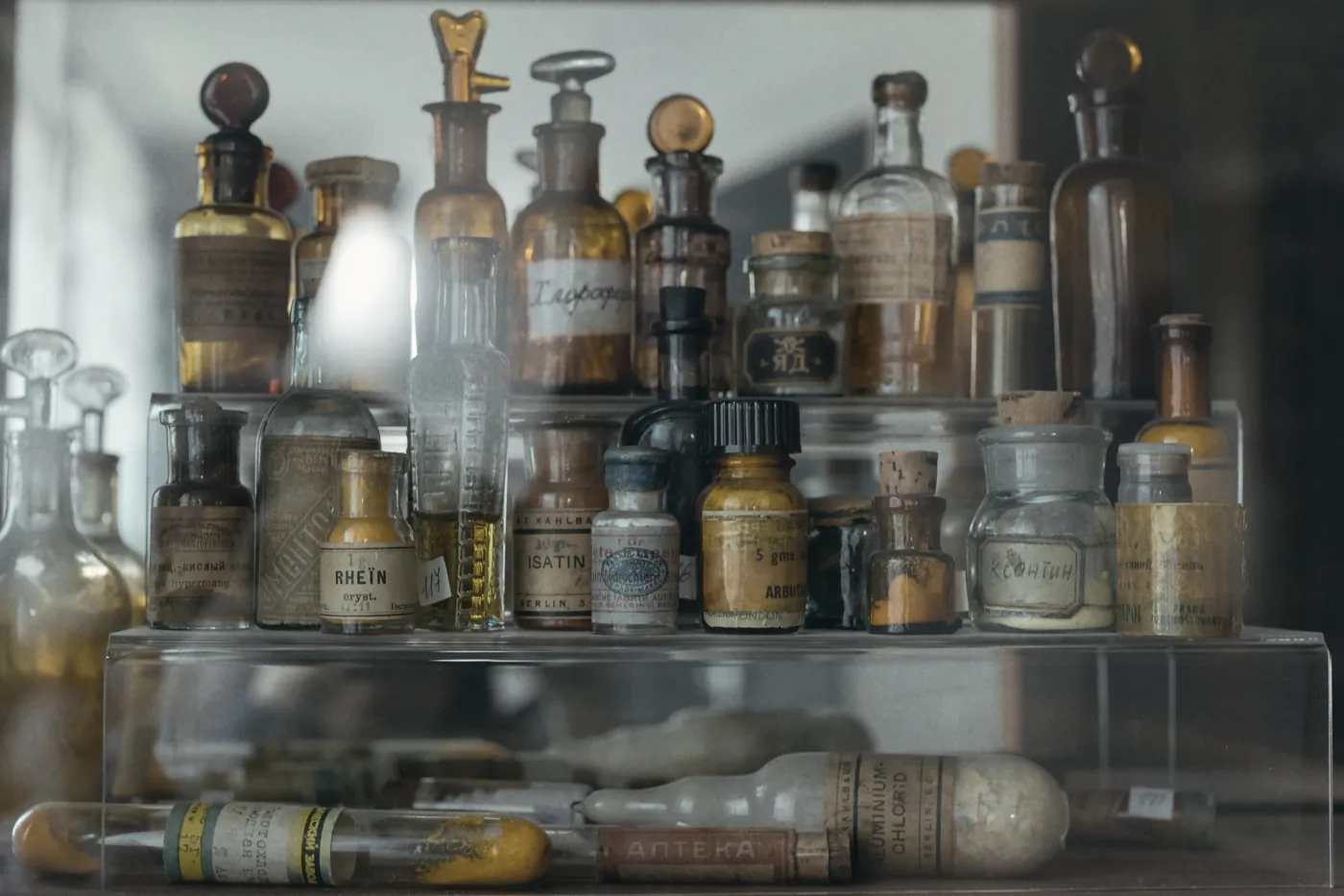 Rows of old glass medicine bottles on shelves