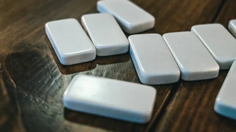 Smooth pale blue rectangular tablets scattered on a dark wooden table