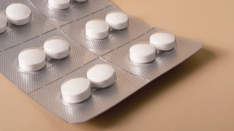 A blister strip of white tablets on an orange background