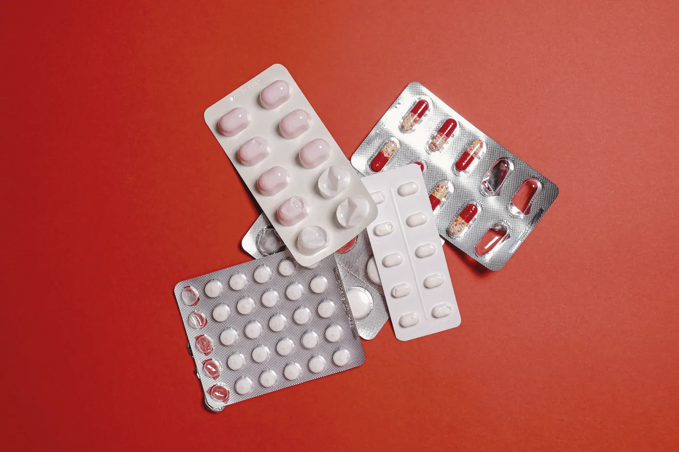 Blister packs of tablets on a red background