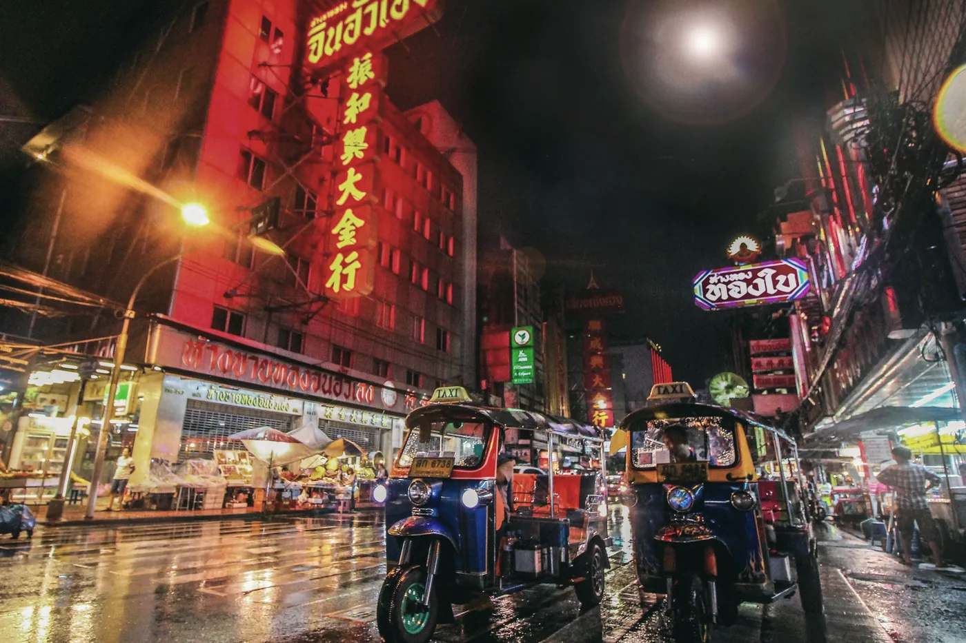 Neon signs over a busy Bangkok street at night