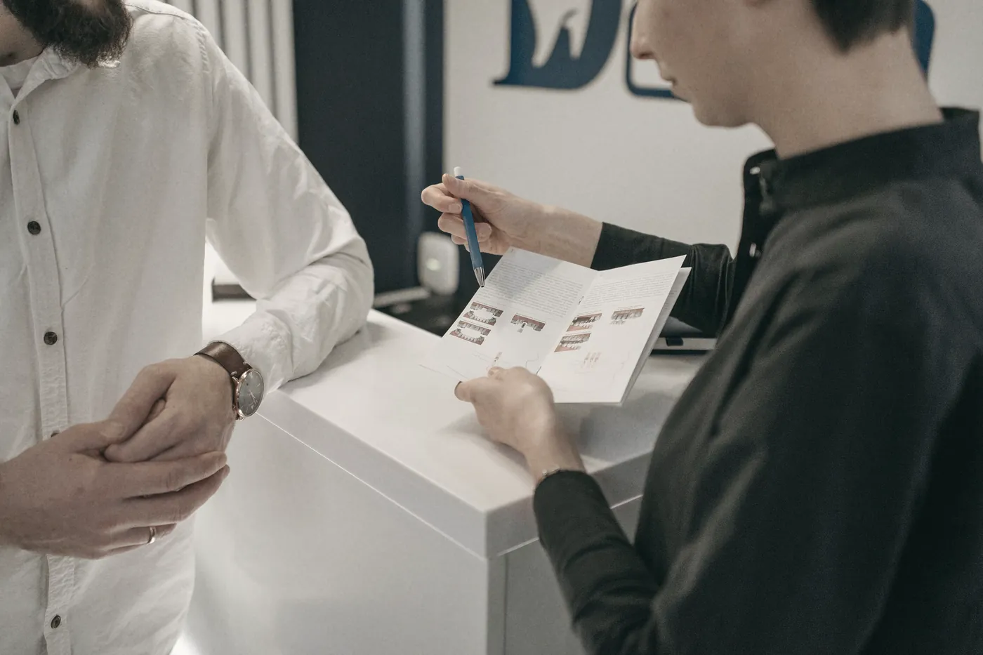 Hands filling in a form at a clinic reception counter