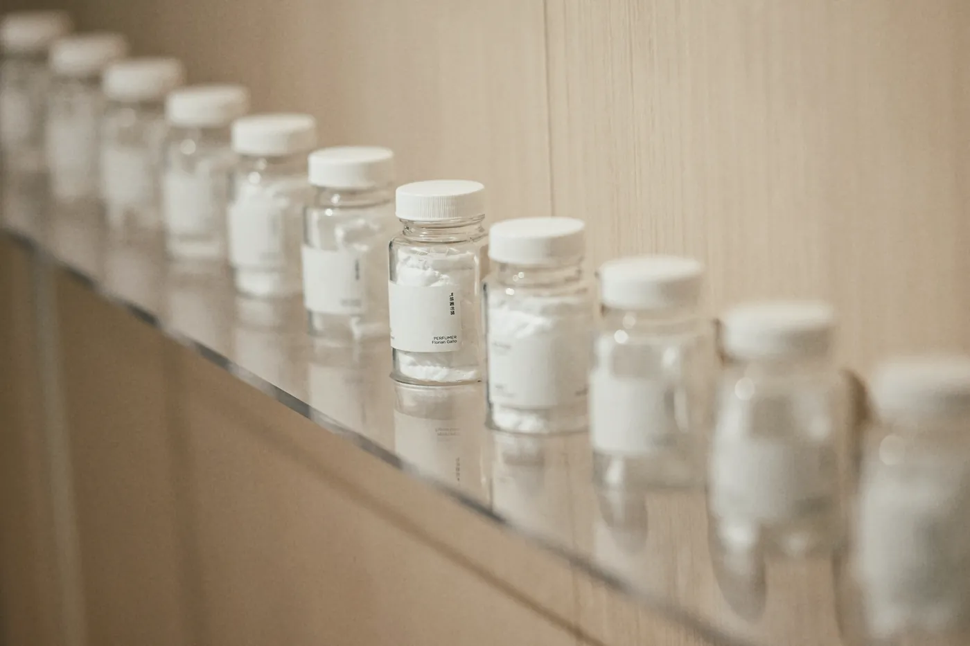 A row of small white medicine bottles on a shelf