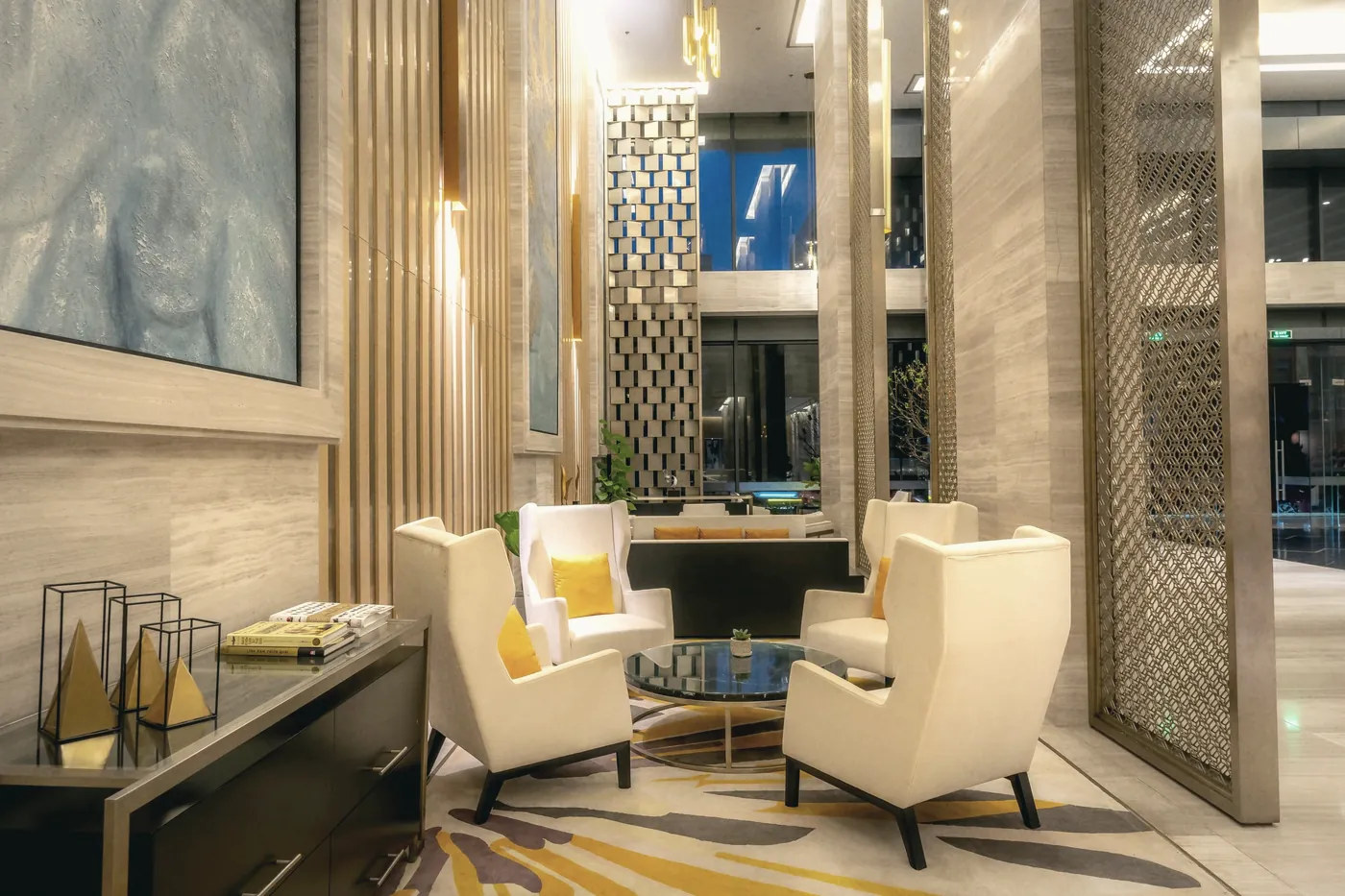 A bright hotel lounge with armchairs and a writing desk