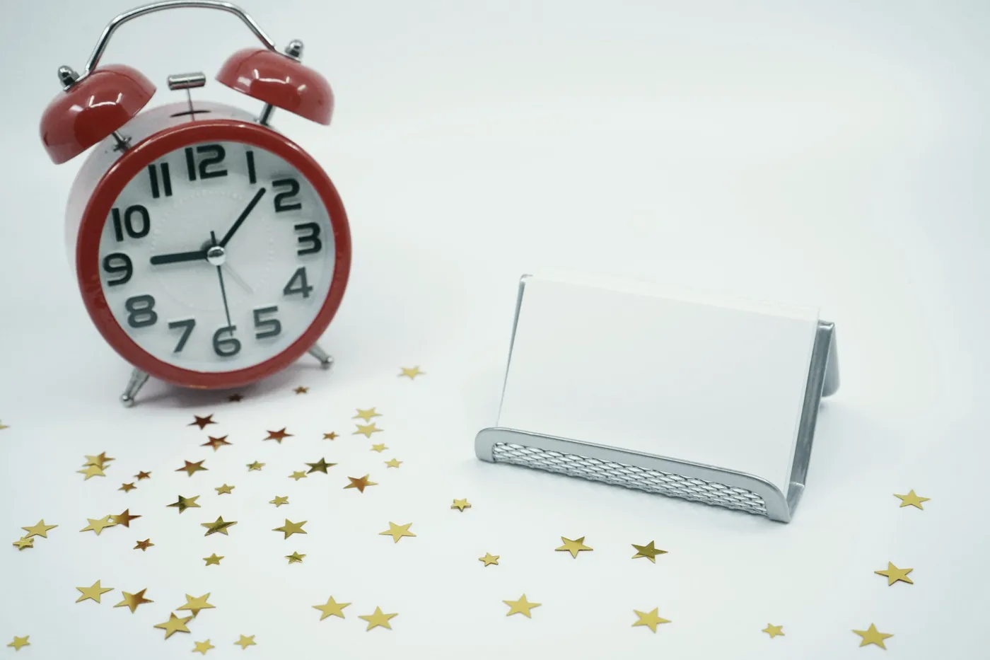 A red alarm clock on a white table