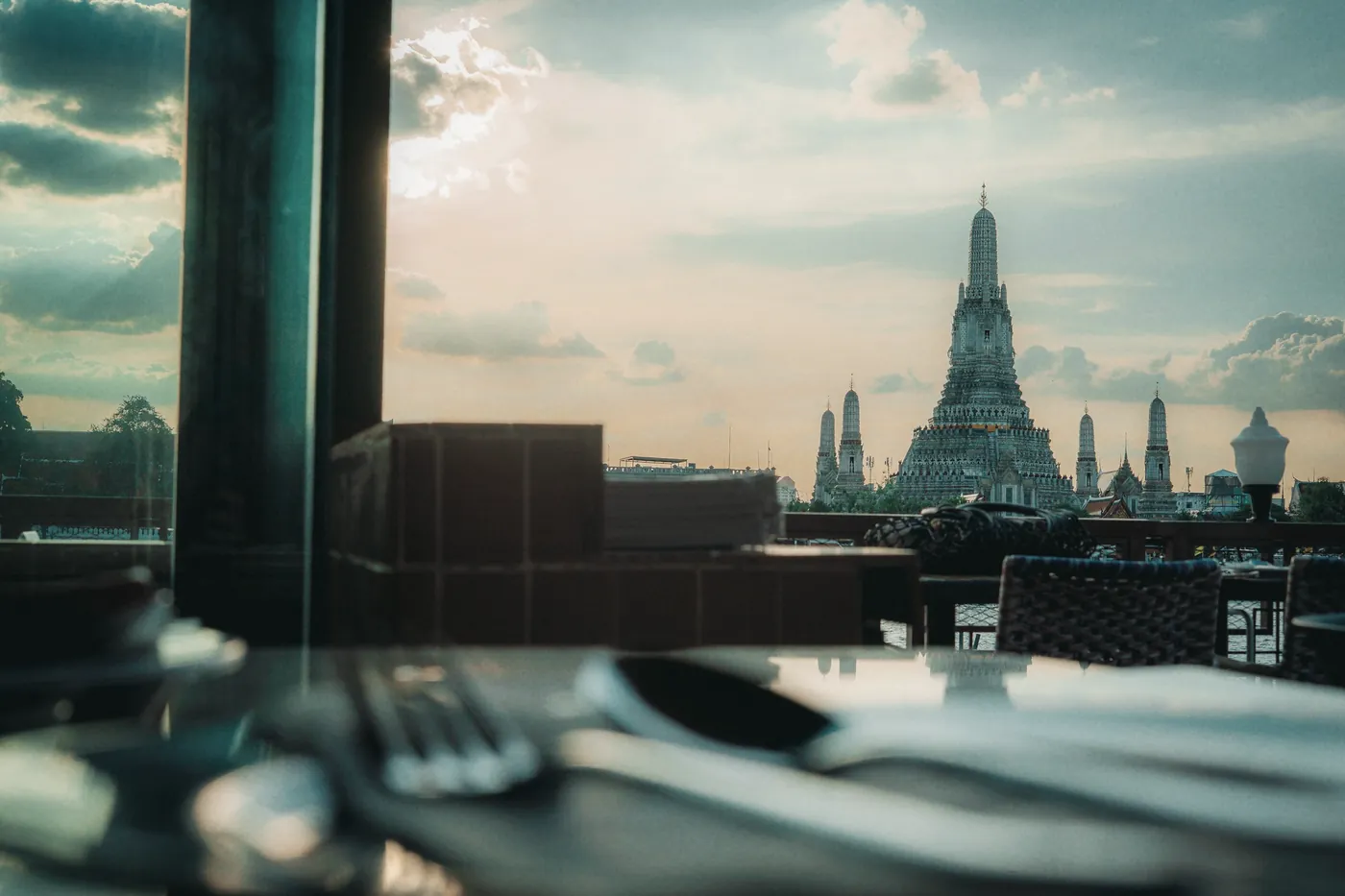 A riverside cafe table looking out at a temple in Bangkok