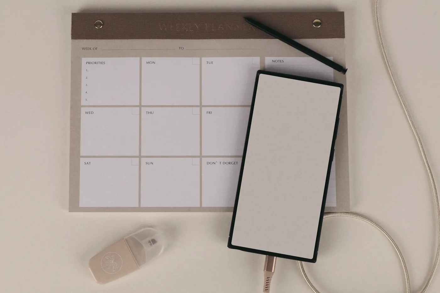 A blank monthly planner and a smartphone on a desk