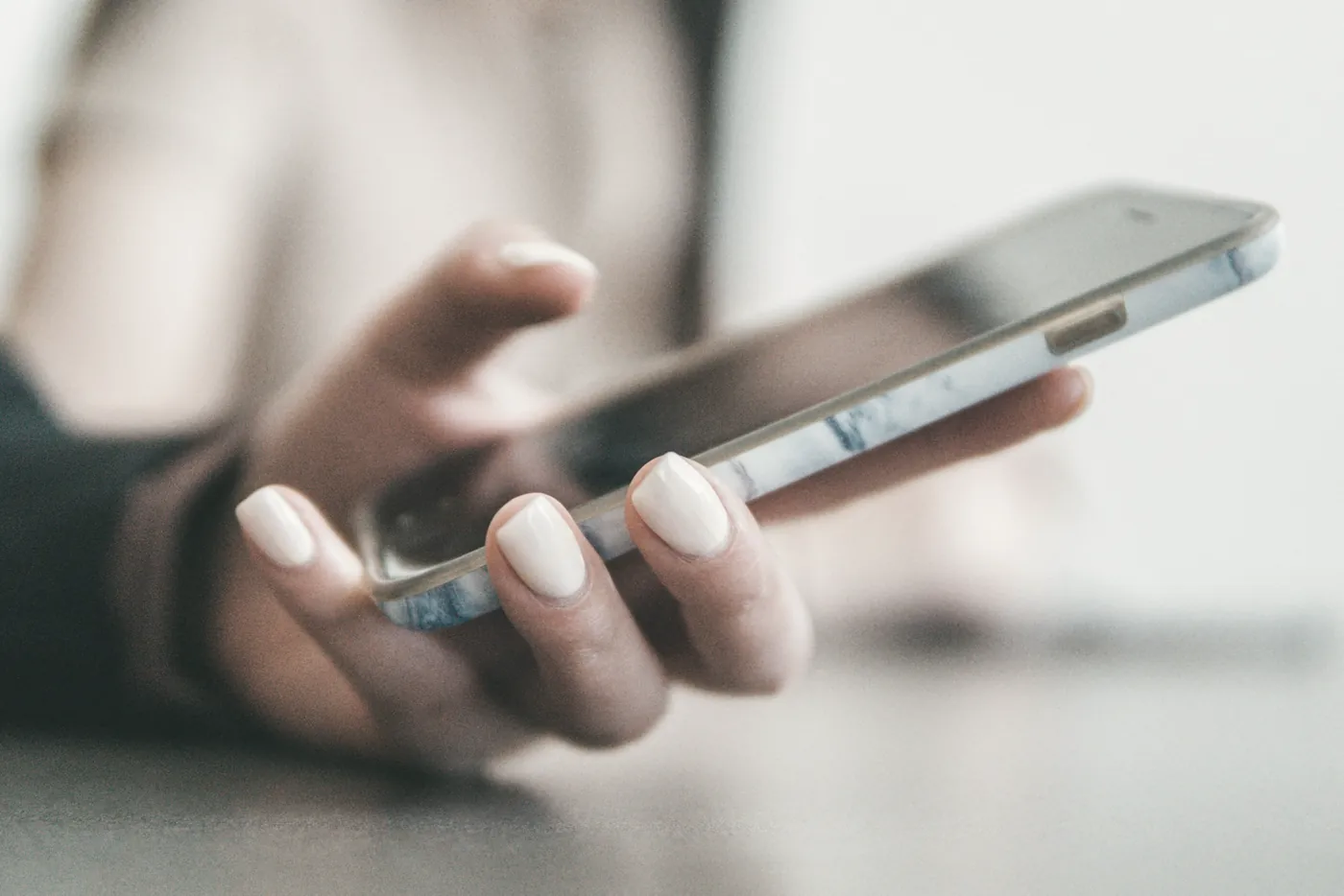 Hands typing a message on a smartphone