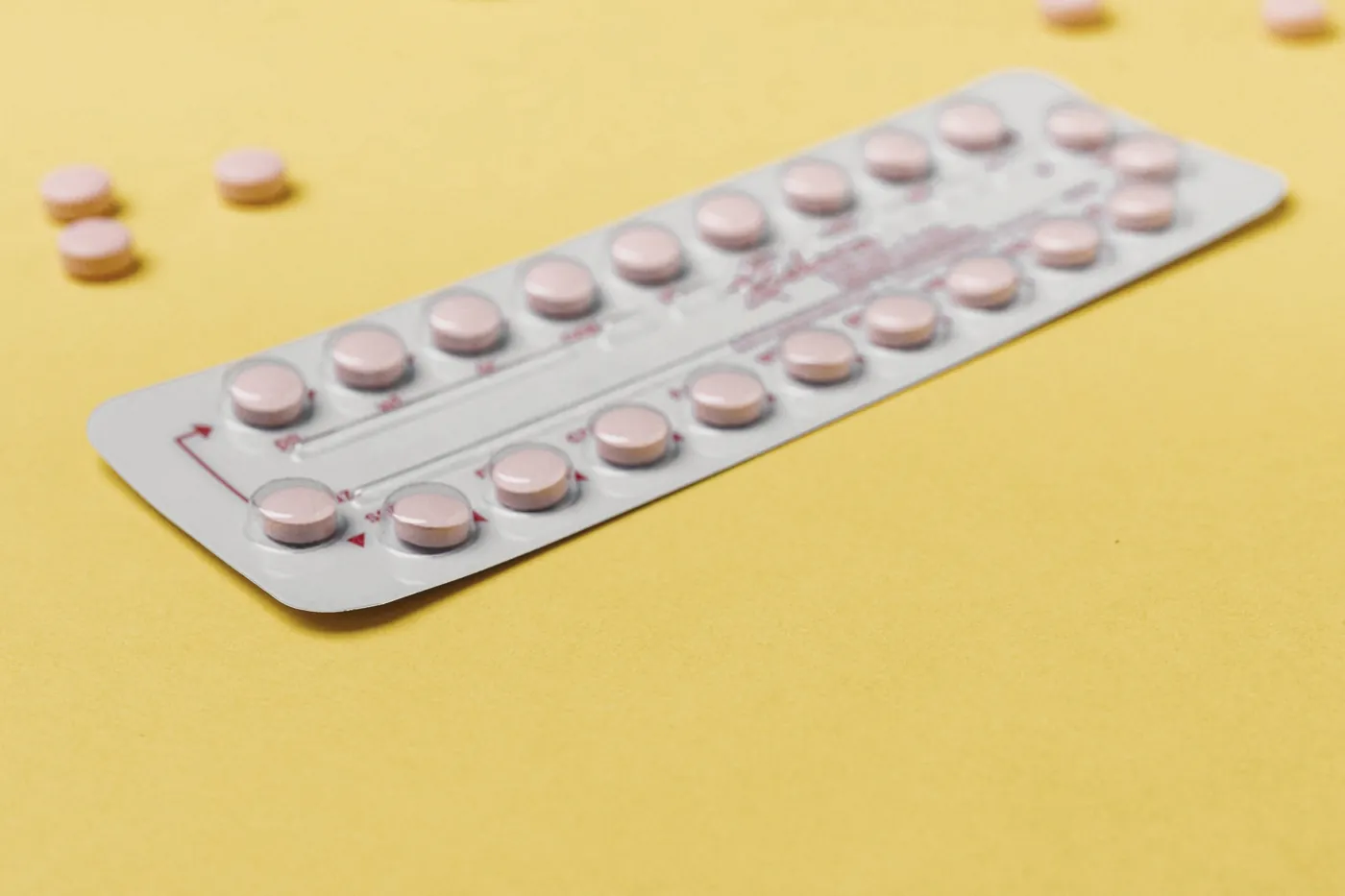 A blister pack of small tablets on a yellow background