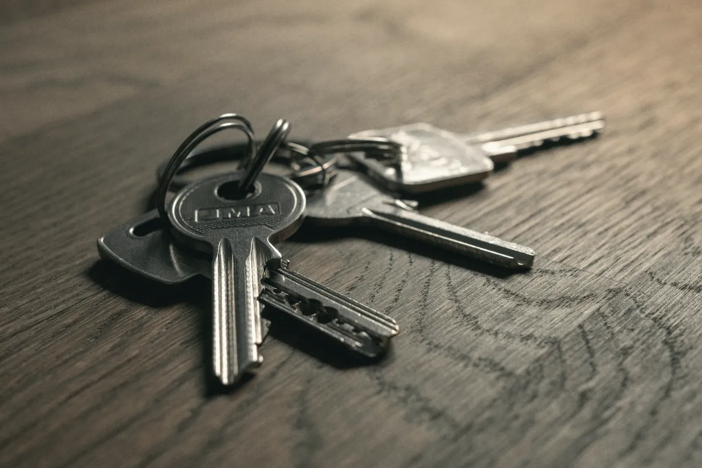Two sets of keys lying on a wooden table